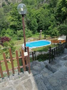 a swimming pool with a light pole and a fence at Chalet di Montagna in San Giuliano