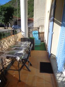 um pátio com uma mesa e cadeiras numa varanda em T2 Anasa em Digne-Les-Bains
