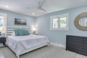 a white bedroom with a bed and a mirror at Luxury Beach House - 2min Walk to Beach - Private Pool - Group & Dog Friendly in Hilton Head Island