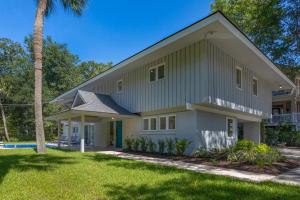 une maison avec un palmier en face dans l'établissement Luxury Beach House - 2min Walk to Beach - Private Pool - Group & Dog Friendly, à Île de Hilton-Head