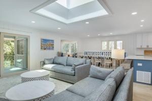 a living room with a couch and a table and a kitchen at Luxury Beach House - 2min Walk to Beach - Private Pool - Group & Dog Friendly in Hilton Head Island