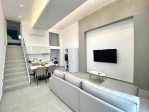 a living room with a couch and a tv on a wall at Hotel Alex in Methoni