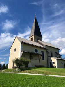 a church with a steeple on top of a field at Ferienwohnung Kendlbacher in Bischofshofen +7 photos