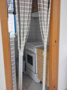 una cucina con piano cottura e una finestra con tende di Villa Grazia a Ostuni