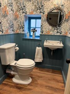 uma casa de banho com um WC e um lavatório em Quaint self contained cottage near Edinburgh. em Loanhead