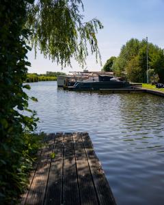 a boat is docked at a dock on a lake at Hotel Zuideinde in Nieuwkoop