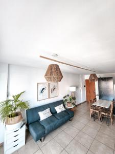 ein Wohnzimmer mit einem blauen Sofa und einem Tisch in der Unterkunft Dpto tipo Duplex c pileta Nva Cba in Cordoba