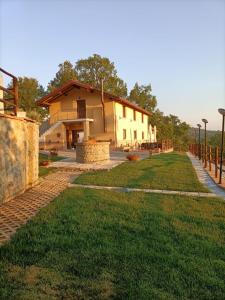 una casa con una valla y un patio de césped en Agriturismo Dolci Ricordi, en Corleto Monforte