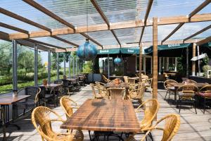 an outdoor patio with tables and chairs and a building at Hotel Zuideinde in Nieuwkoop