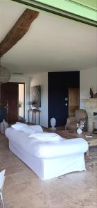 にあるClos de la fontaineの白いベッド4台が備わるソファ付きの客室です。