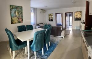 ein Esszimmer mit einem weißen Tisch und grünen Stühlen in der Unterkunft 3 Bedroom Apartment with pool in Čeluga