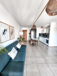 ein Wohnzimmer mit einem blauen Sofa und einer Küche in der Unterkunft Dpto tipo Duplex c pileta Nva Cba in Cordoba