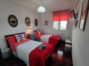 two beds in a room with red sheets and red pillows at Laredo Ocean Port in Laredo