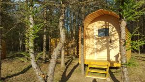 a tiny house in the woods with a bench at Glamping Pod im Wald in Nordholz