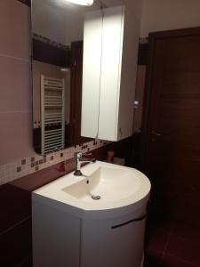 ein Badezimmer mit einem weißen Waschbecken und einem Spiegel in der Unterkunft Casa Tevere in Syrakus