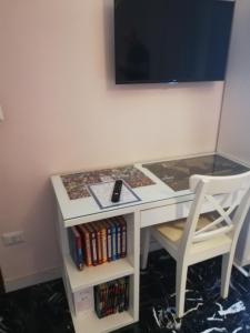 einen weißen Schreibtisch mit einem Stuhl und einem Monitor in der Unterkunft Casa Tevere in Syrakus