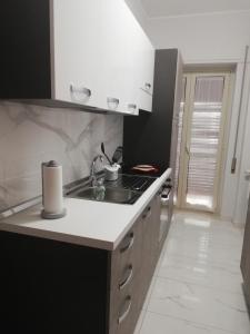 eine Küche mit einer Spüle und einer Arbeitsplatte in der Unterkunft Casa Tevere in Syrakus