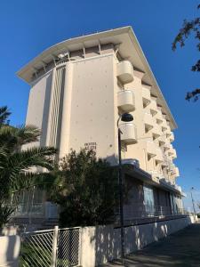 a large white building with a street light in front of it at Hotel Audi Frontemare in Rimini