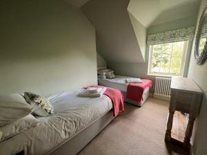 a bedroom with two beds and a window at Quaint self contained cottage near Edinburgh. in Loanhead