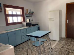 eine Küche mit einem blauen Tisch und einem Kühlschrank in der Unterkunft Finca Tylia, Olta, Calpe in Benissa + 9 Fotos