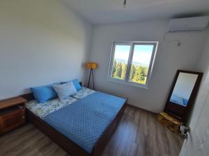 a small bedroom with a bed and a mirror at Linda apartment in Ulcinj