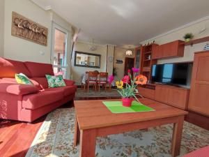 uma sala de estar com um sofá vermelho e uma mesa em Laredo Ocean Port em Laredo