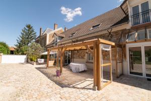 a wooden pergola on the side of a house at Ferme d'Auxonnettes in Saint-Fargeau-Ponthierry