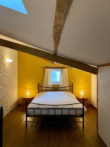 a bedroom with a bed in a room with yellow walls at Domaine de la Laigne - Spa in Asnières-la-Giraud