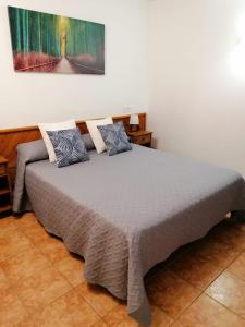 een bed in een kamer met een schilderij aan de muur bij Cala Ferrera HOME&ME in Felanitx