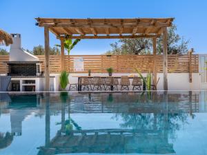 a swimming pool with a wooden pergola and a patio at Sonel Luxury Villa, a Family Retreat, By ThinkVilla in Mouzákion