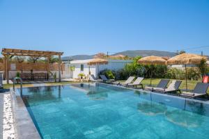 a swimming pool with chairs and umbrellas at Sonel Luxury Villa, a Family Retreat, By ThinkVilla in Mouzákion
