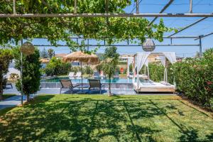 a garden with chairs and a swimming pool at Sonel Luxury Villa, a Family Retreat, By ThinkVilla in Mouzákion