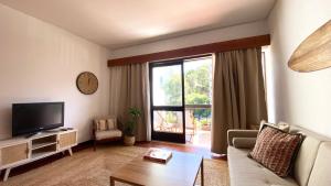 un soggiorno con divano e TV di Estoril Sunny Apartment a Estoril