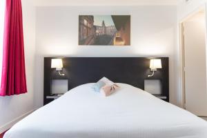 a white bed with a pink bow on top of it at Toulouse Fluvia in Toulouse