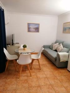 een woonkamer met een bank en een tafel en stoelen bij Cala Ferrera HOME&ME in Felanitx