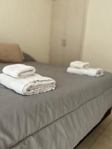 2 toallas están apiladas en la parte superior de una cama en Departamentos Hipolito Yrigoyen en San Rafael