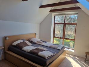 a bed in a room with a large window at Elling Bed & Breakfast in Frederikshavn