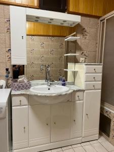 ein Bad mit einem Waschbecken und einem Spiegel in der Unterkunft Ferienhaus Seeröschen - Gesamte Unterkunft in Pörtschach am Wörthersee