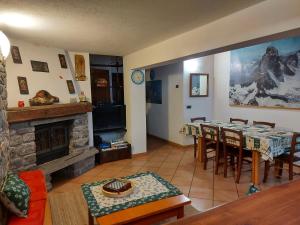 een woonkamer met een tafel en een open haard bij La Taverna Alloggio ad uso turistico - VDA -Sarre - CIR- 0073 in Aosta