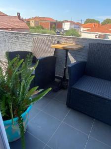 un patio con 2 sillas, una mesa y una planta en Apartment Ella en Zadar