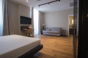 a bedroom with a bed and a living room with a couch at PALAZZO DANISI ROOMS&SUITES in Bari