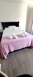 een roze bed met een roze deken en slippers erop bij demis Mykonian soul 2 in Platis Yialos Mykonos