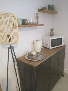 a table with a microwave and a lamp on it at La Chouette Villa ,chambre de 20m2 totalement indépendante avec terrasse in Cannes-et-Clairan