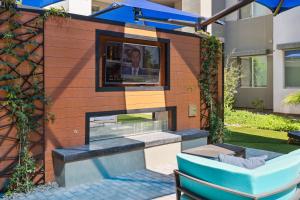 een patio met een bank en een tv aan de muur bij Kasa Scottsdale North Phoenix in Scottsdale
