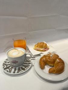 a white plate topped with a donut and a cup of coffee at B&B Il Corso in Siena
