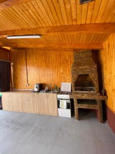 a kitchen with a stove and a stone oven at Pensiunea La Doinel in Densuş