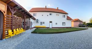a building with yellow chairs in front of a building at Pensiunea La Doinel in Densuş