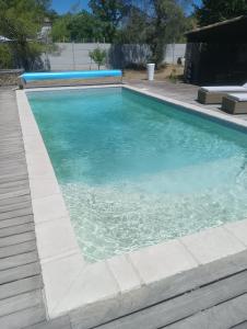 a swimming pool with blue water in a yard at La Chouette Villa ,chambre de 20m2 totalement indépendante avec terrasse in Cannes-et-Clairan
