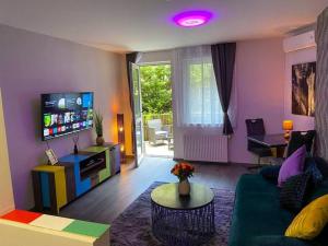 ein Wohnzimmer mit einem grünen Sofa und einem TV in der Unterkunft H & A Suite Gozsdu - THE 1001 NIGHTS SUITE in Budapest