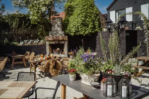 a patio with a table with flowers and a fireplace at The Bonnie Badger in Gullane